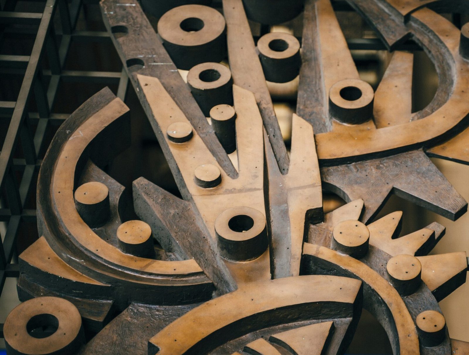 Abstract mechanical sculpture of large interlocking gears representing structured leadership, team coordination, and strategic alignment at MaestroVox Advisors.
